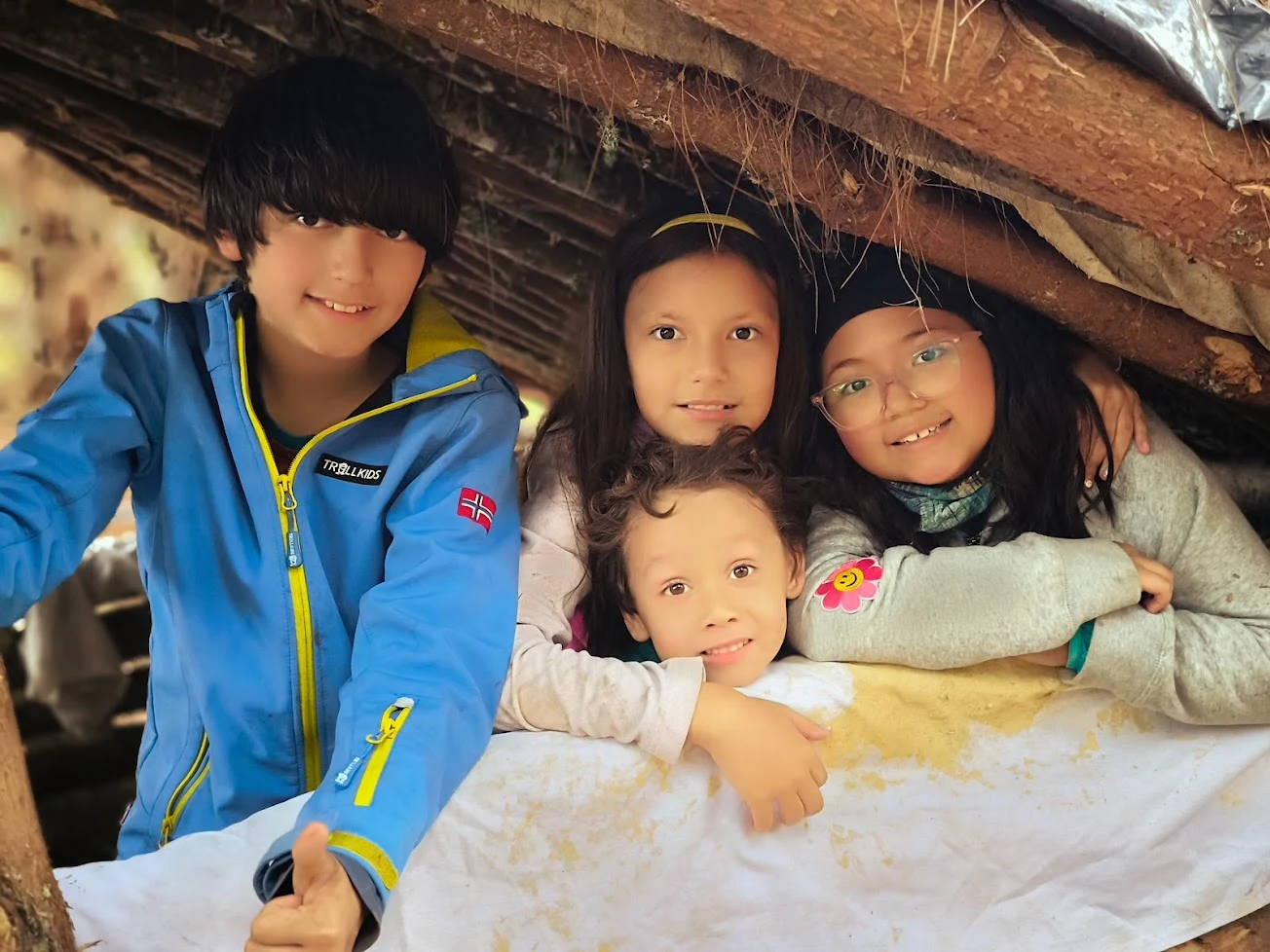 Amigos compartiendo un refugio construido en el bosque