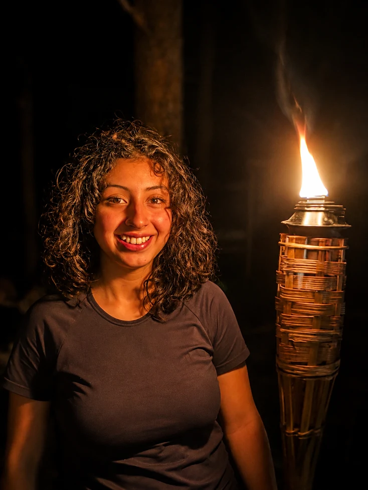 Participante junto a una antorcha durante una noche de campamento